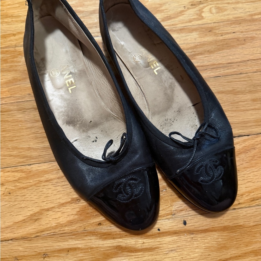 CHANEL Black Leather Ballet Flats with Patent Cap Toe and CC Emblem